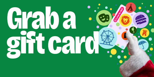 Santa Claus holding up a Lovetovisit Gift Card