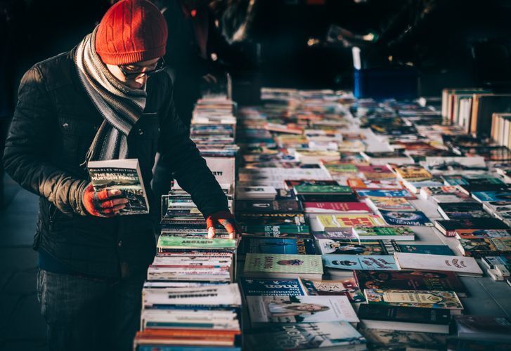 Person searching through piles of books