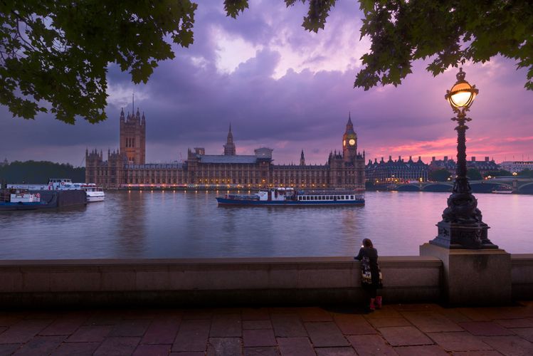 Big Ben and the Houses of Parliament at dusk, a woman stood alone