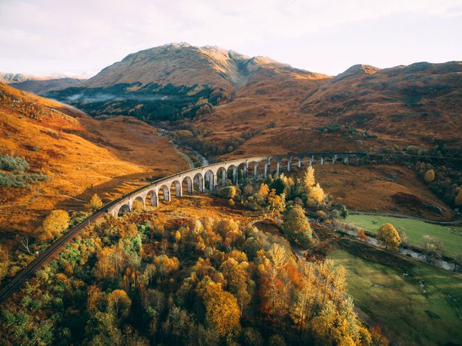 Viaduct with train tracks curving through Scottish countryside in autumn 