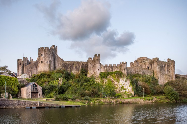 © 2018-2022 Welsh Government. Pembroke Castle walls surrounded by water